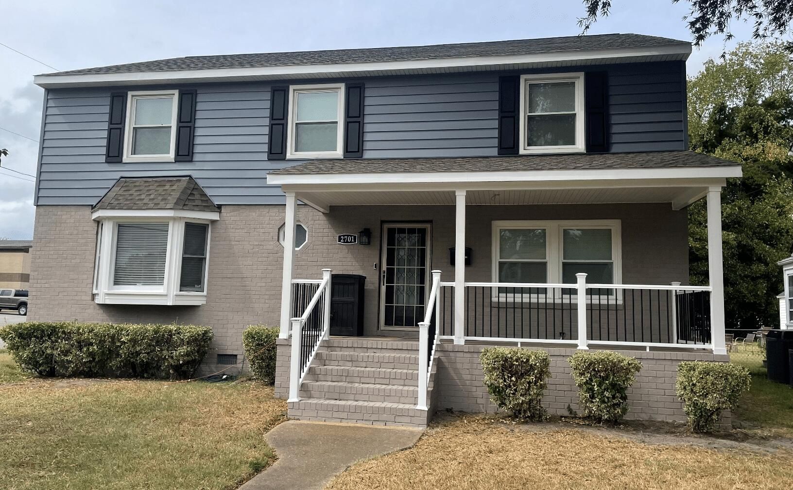 A house with a porch and stairs in front of it.