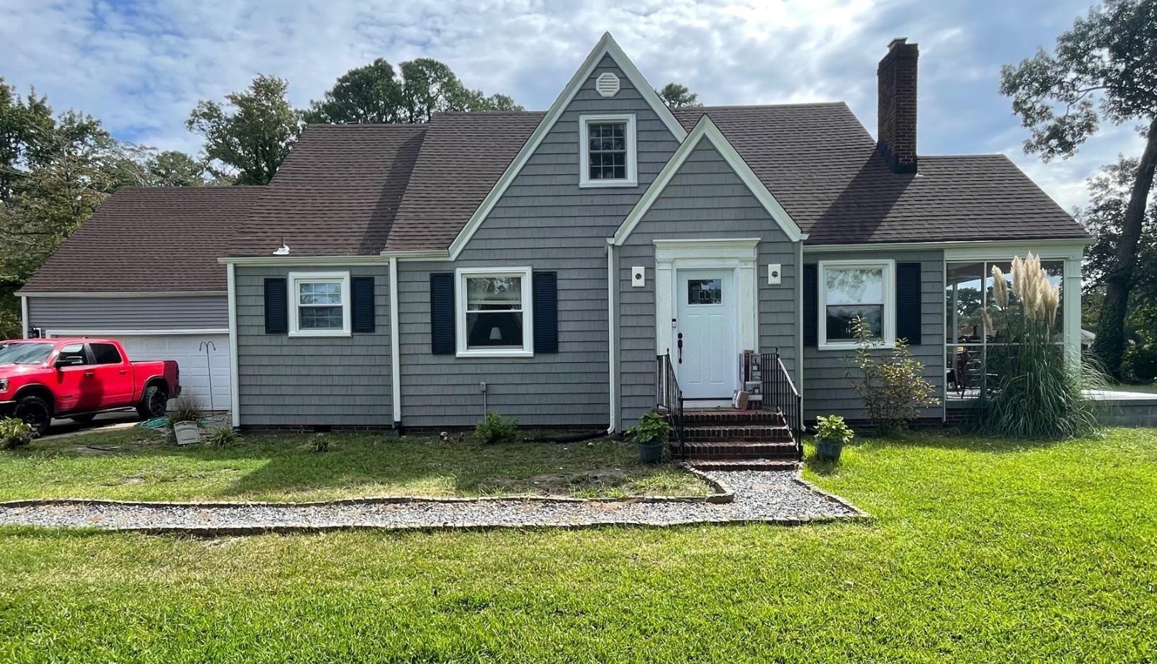 A large house with a red truck parked in front of it.