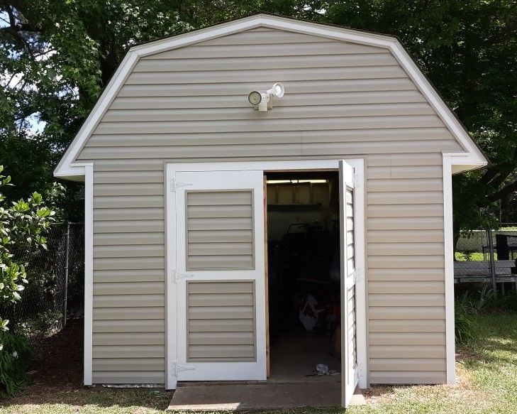 A barn with the door open and a light on top of it