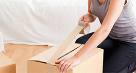 woman placing packing tape on a box
