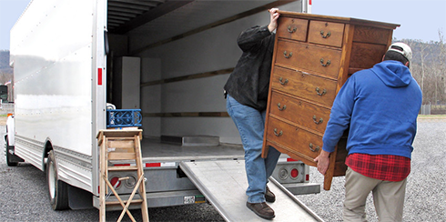 movers carrying a wooden cabinet