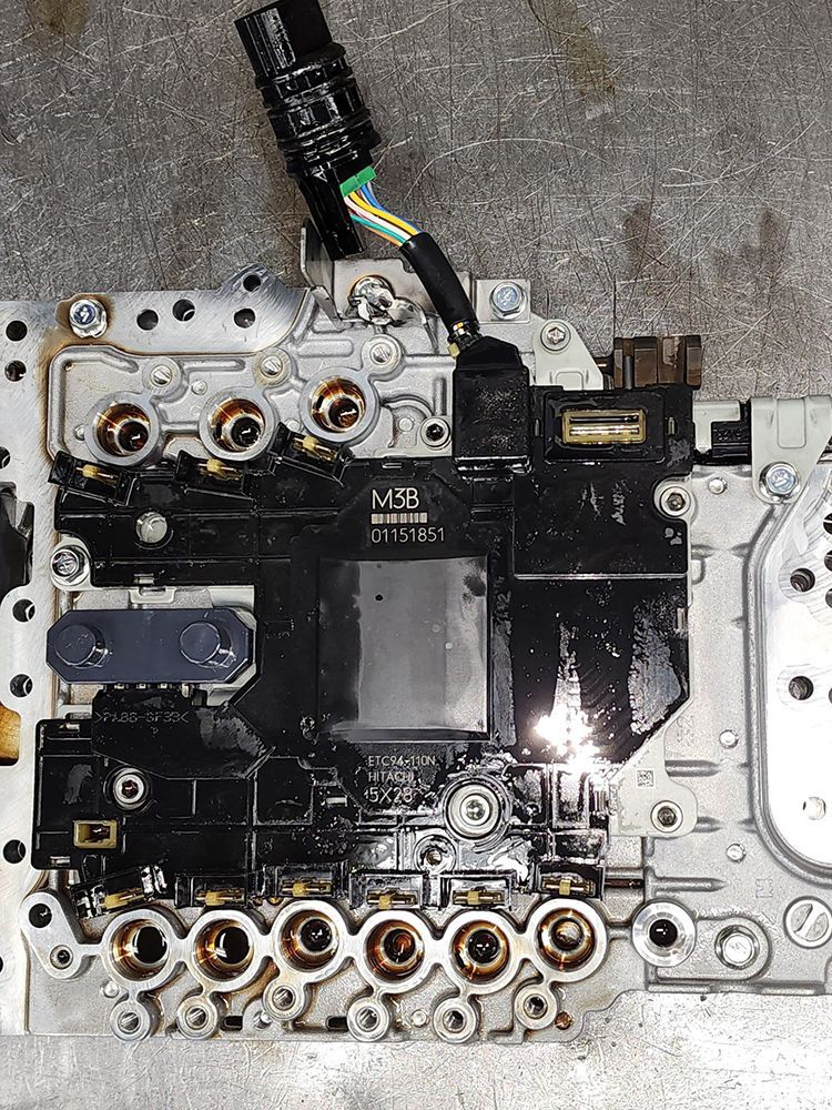 Transmission valve body with electrical connector, showing internal components.