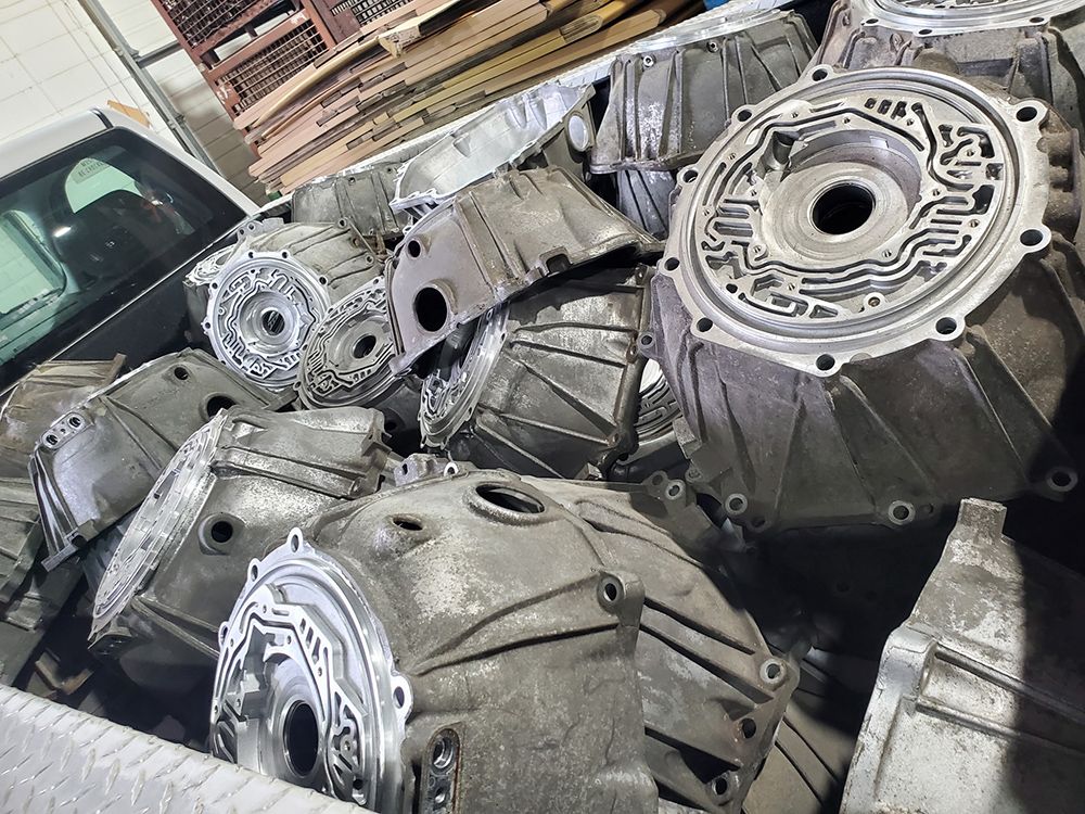 Pile of aluminum transmission housings in a pickup truck bed.
