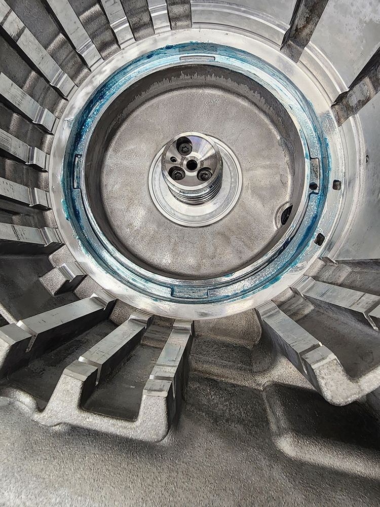 Close-up view of a circular, metallic industrial component with a blue sealant ring.