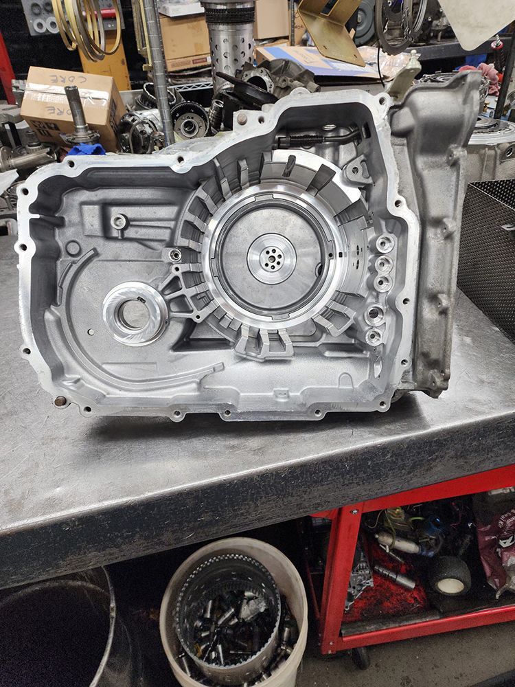 Open aluminum automotive transmission casing on a workbench.