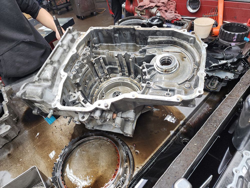 Open car transmission, partially disassembled on a workbench.