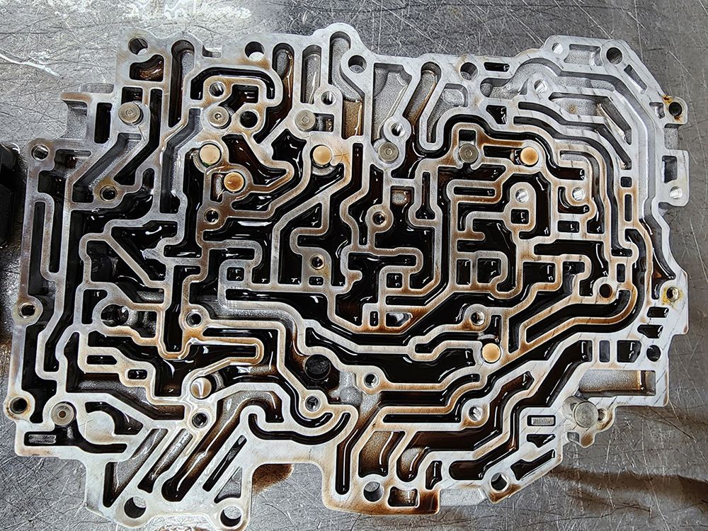 Valve body from an automatic transmission, with intricate fluid passages and bolt holes.