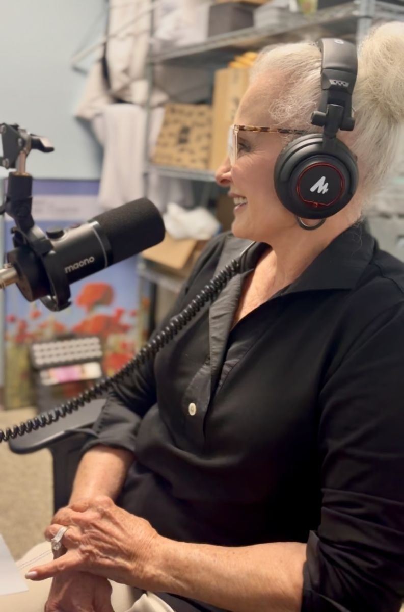 Woman with headphones and microphone; podcast recording.