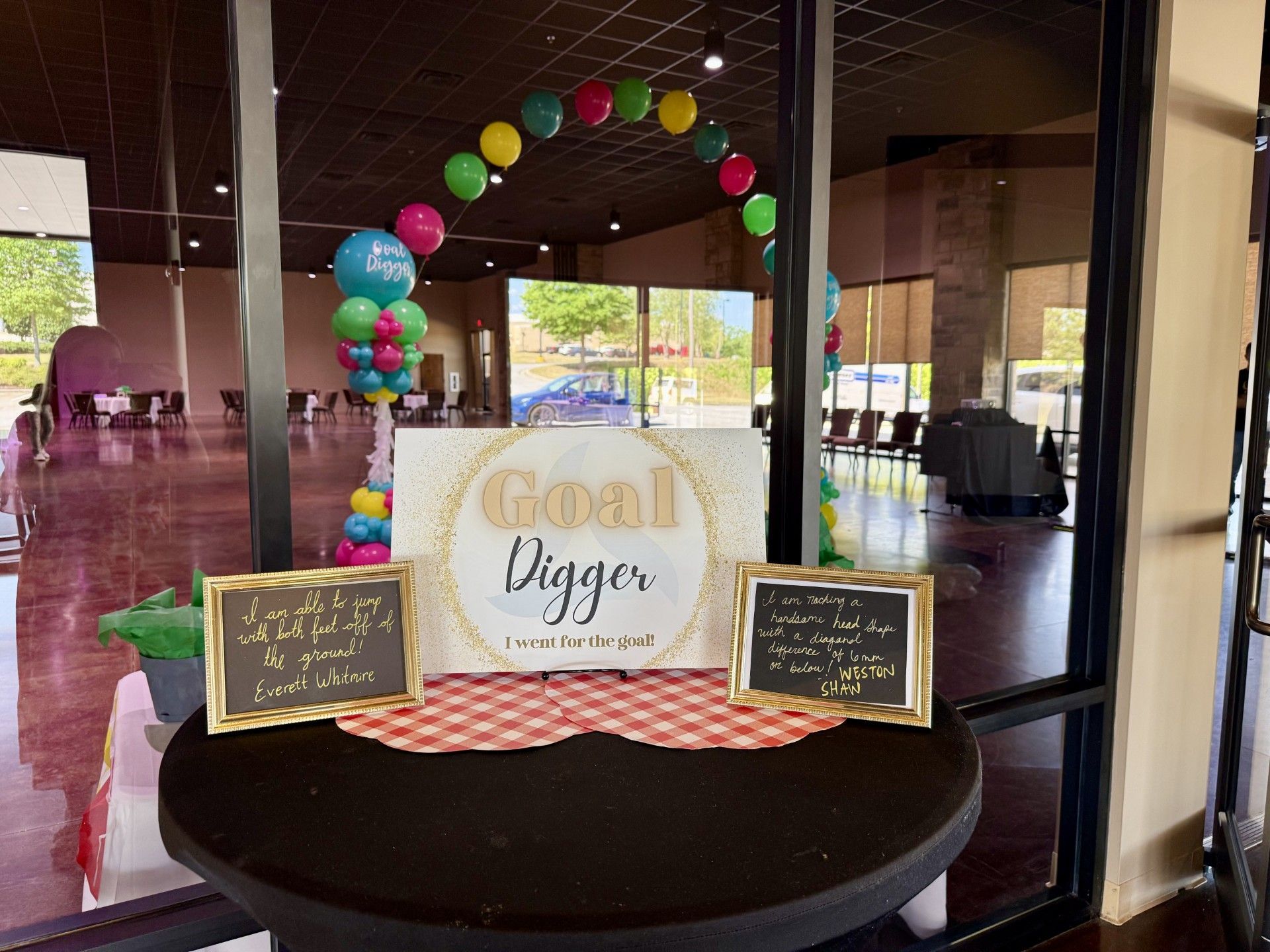 Goat Diggity dessert table with balloon arch and chalkboard signs in a lobby