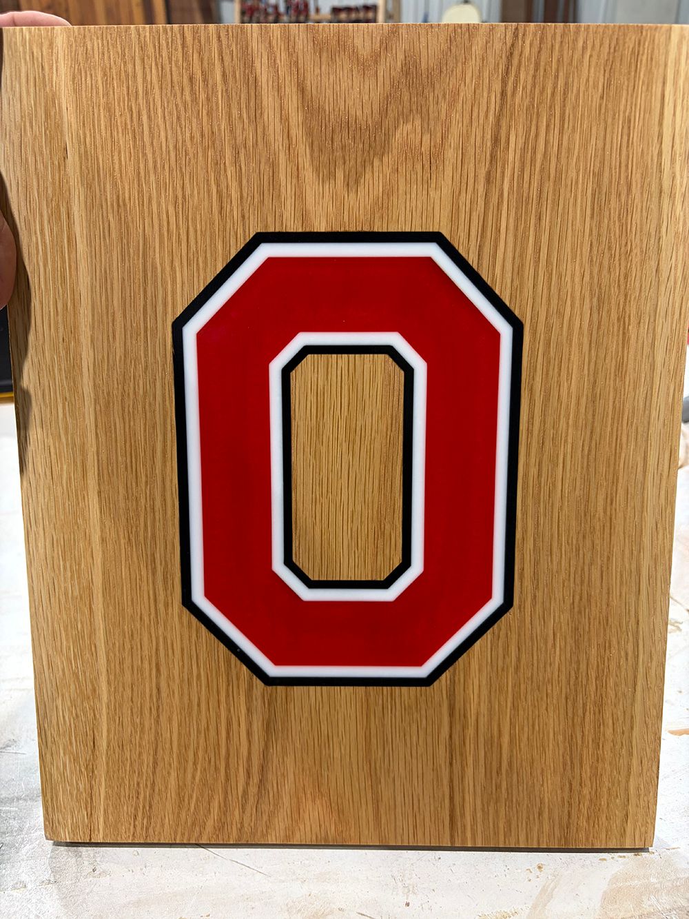 Red “O” letter on a wood-grain background.