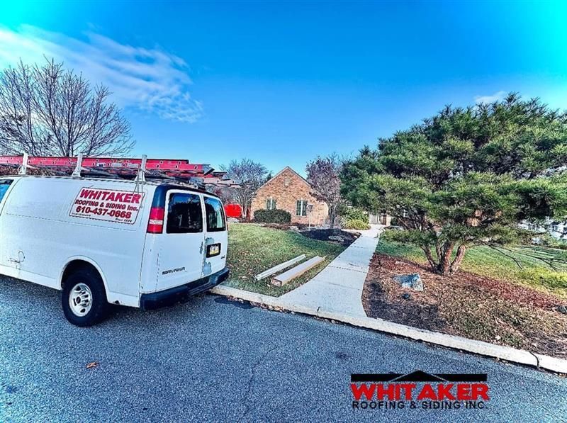 A white van is parked in front of a house.