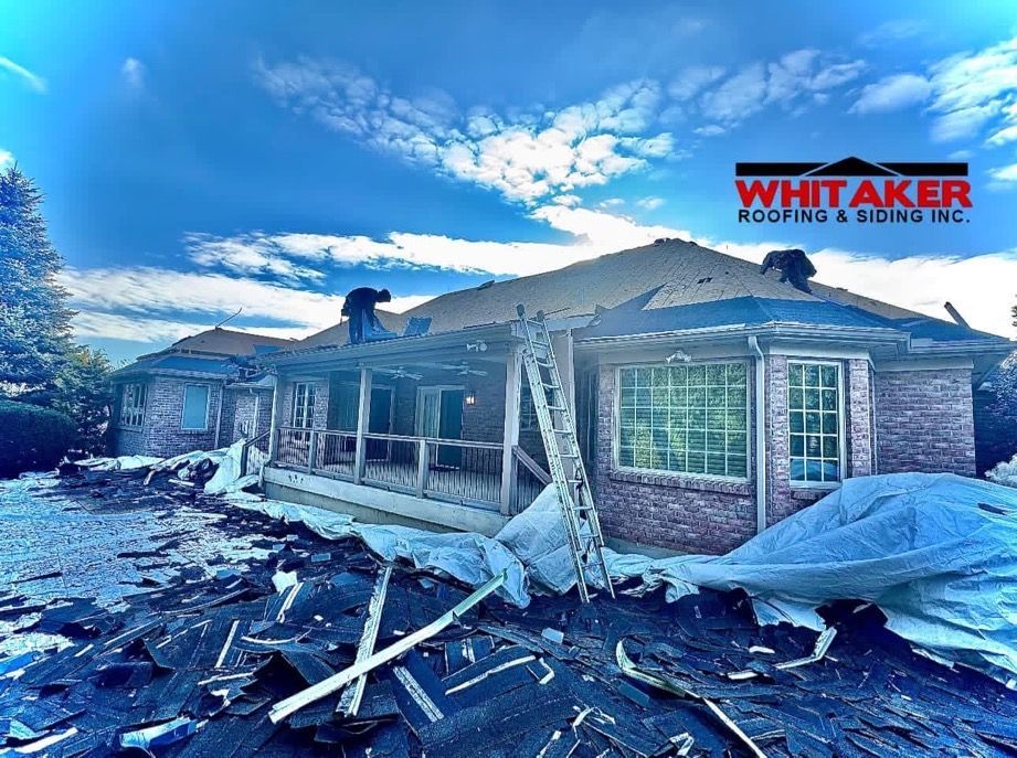 A roofer is working on the roof of a house.