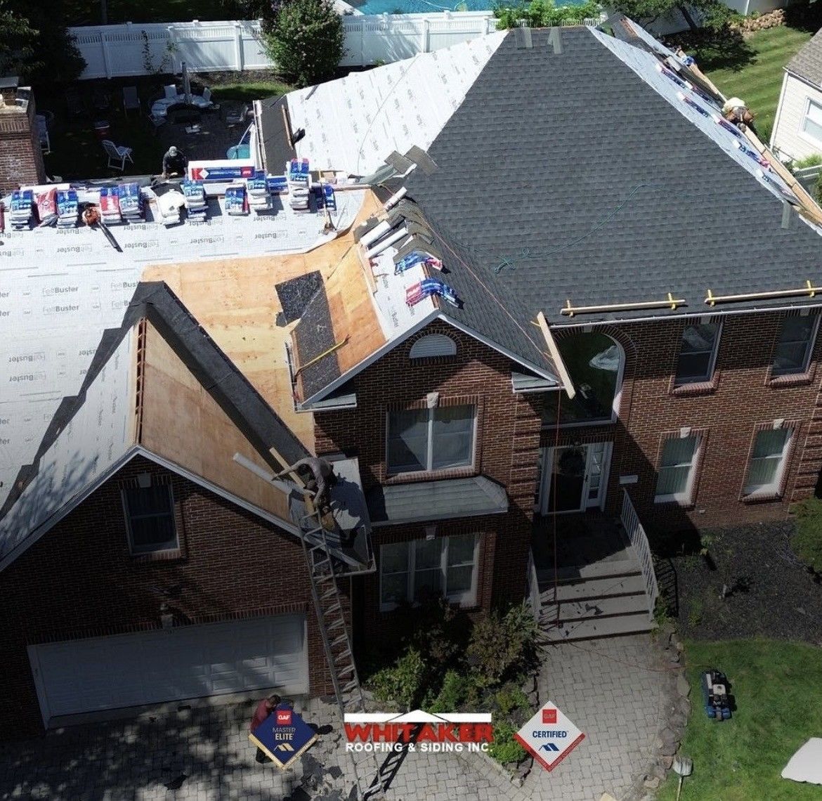 Roof replacement in progress on a brick house. Partially covered with new shingles and underlayment.