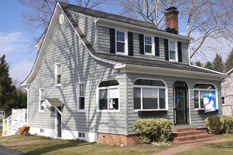 A gray house with black shutters on the windows