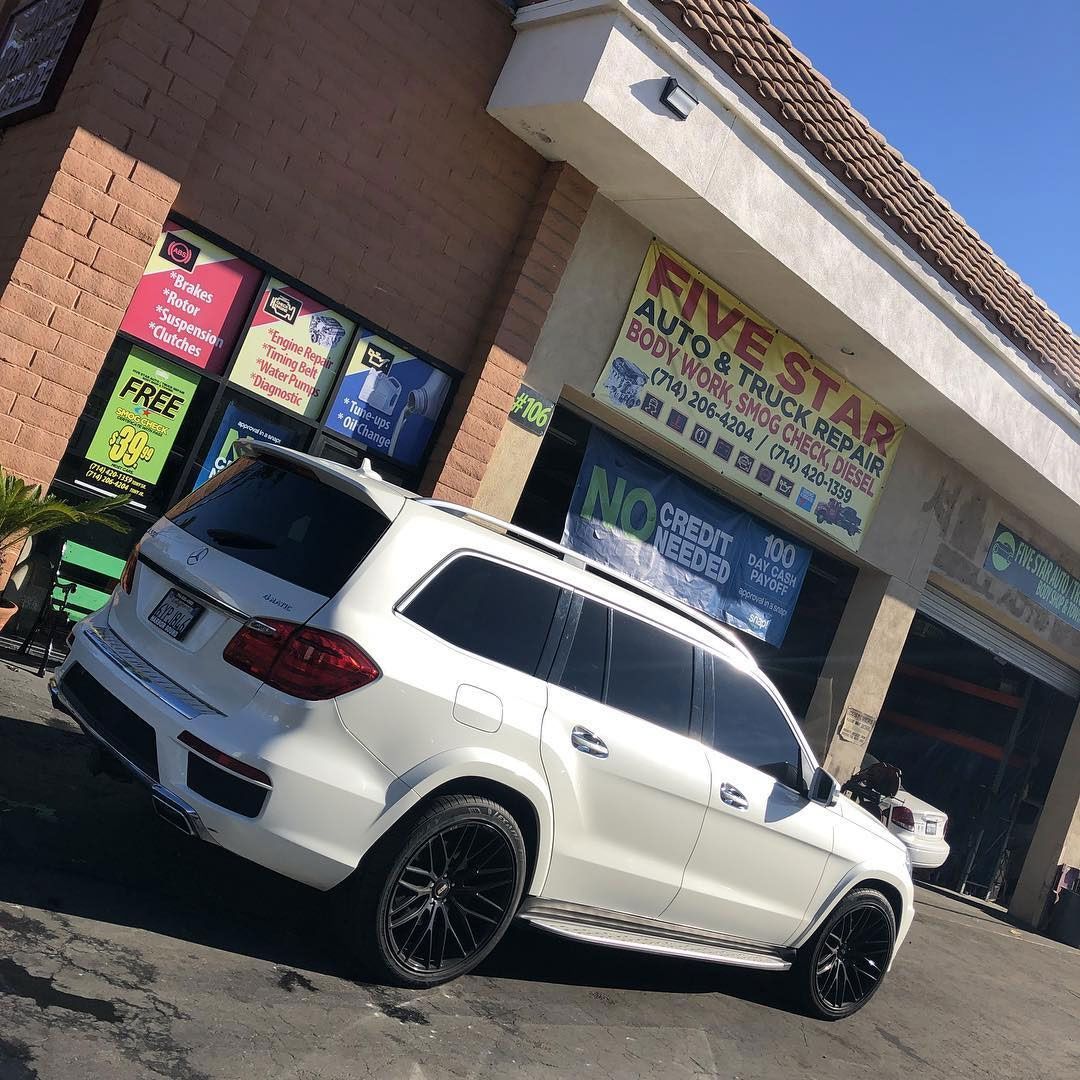 White SUV parked outside a business called Five Star Auto & Truck Repair.