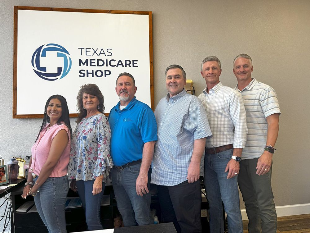 A group of people are posing for a picture in front of a sign that says texas medicare shop.