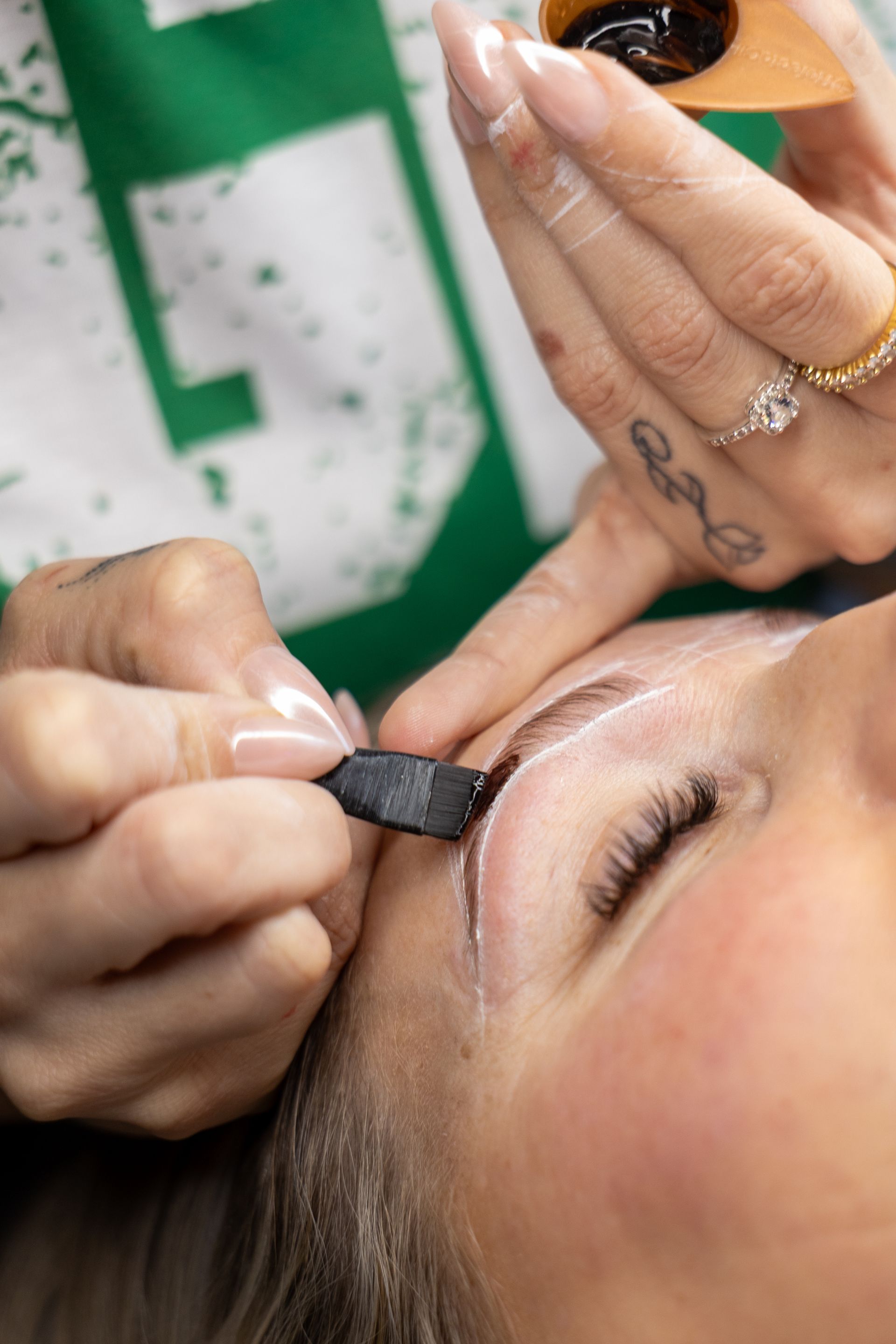Applying eyebrow makeup with a small brush to a close-up face