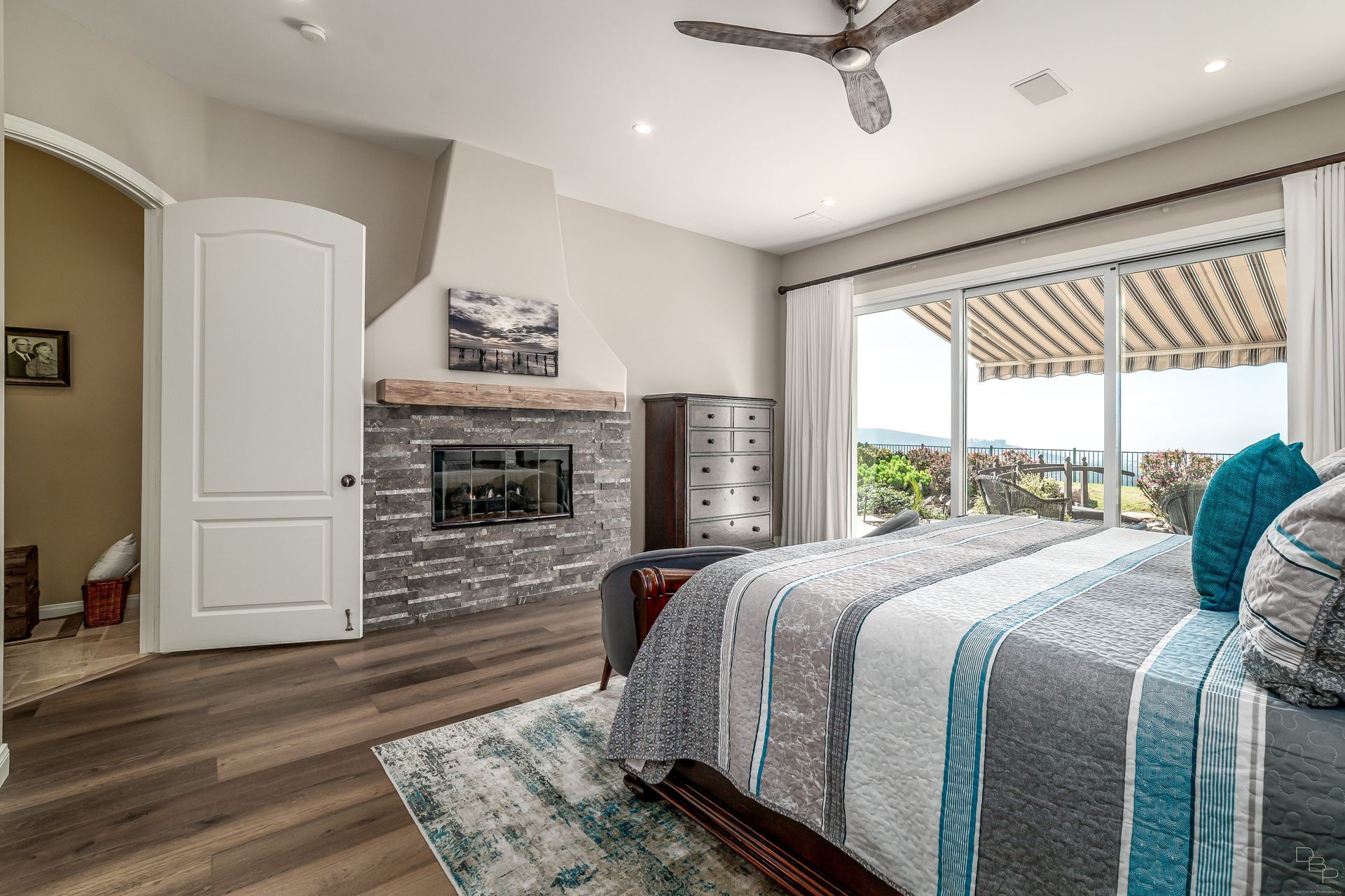 A bedroom with a bed , fireplace , and sliding glass doors.