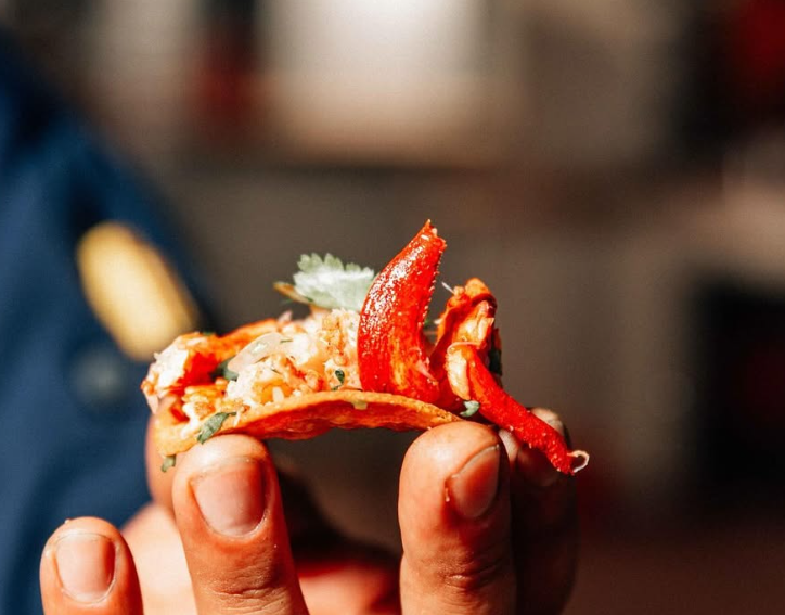 A person is holding a piece of food in their hand.