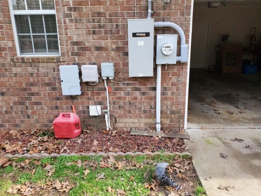 Brick house exterior with utility meters, white pipes, and a red gas can beside an open garage entrance