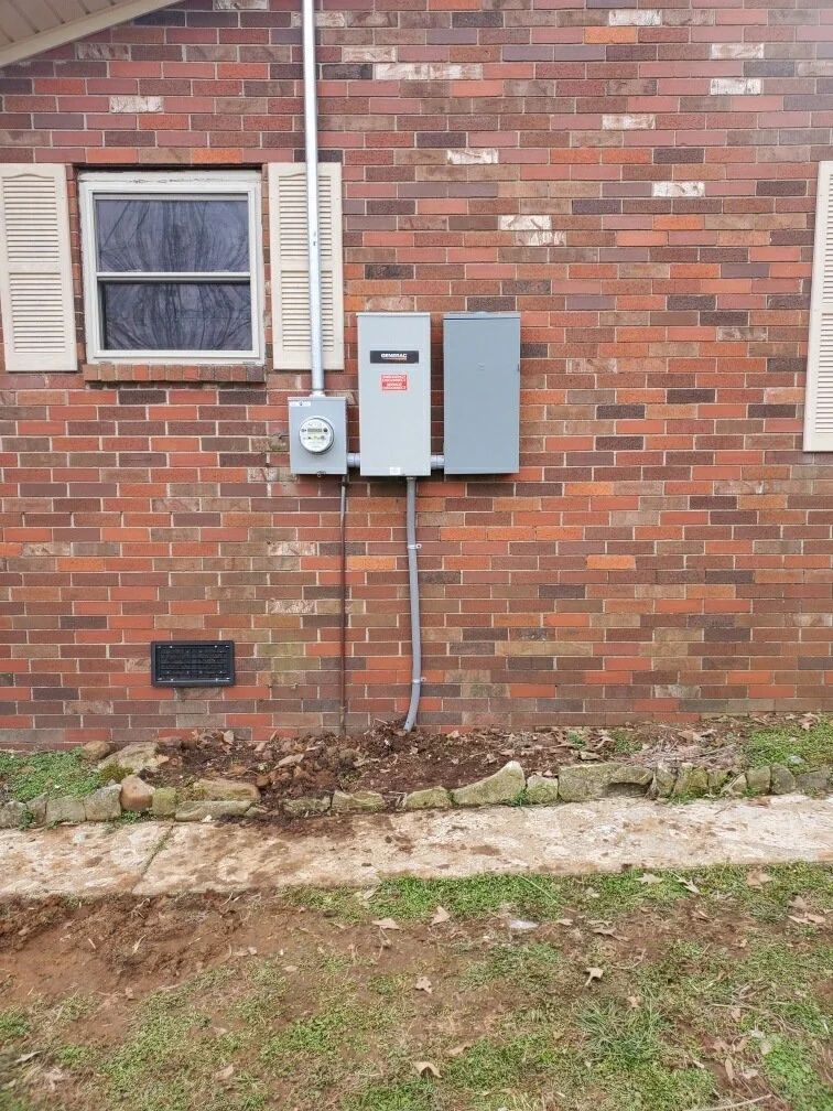Brick house exterior with window, utility meters, and electrical boxes mounted on the wall