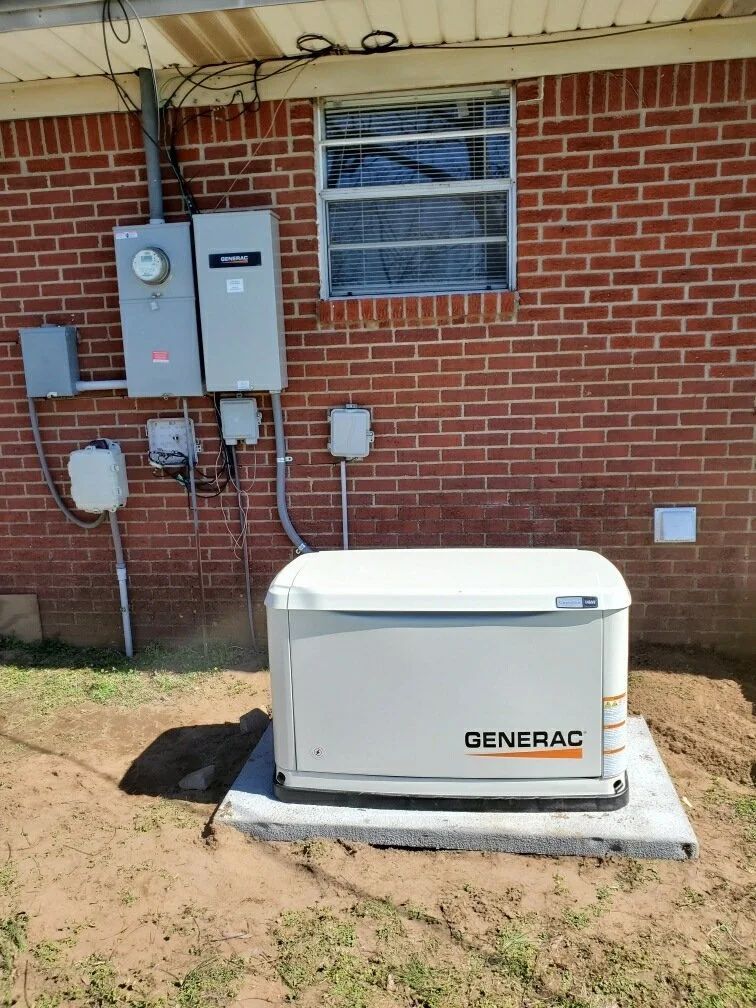 Generac backup generator beside a brick house with electrical panels and utility boxes attached to the wall