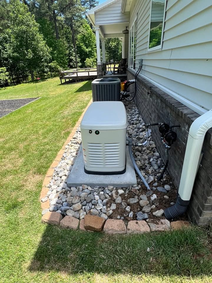 Outdoor air conditioner units beside a house on a gravel bed with stone border and green lawn