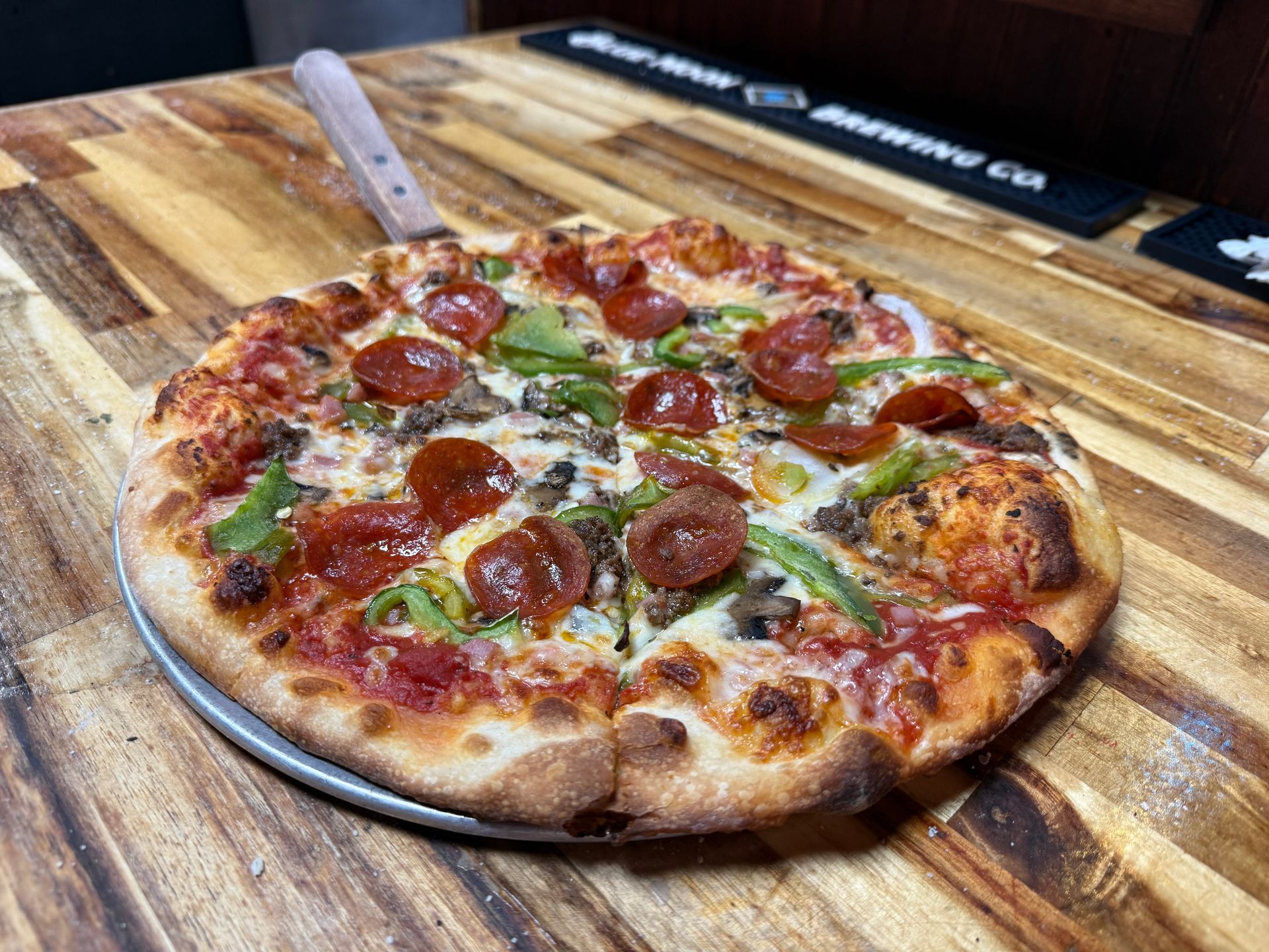 A pizza with a lot of toppings on it is on a table.