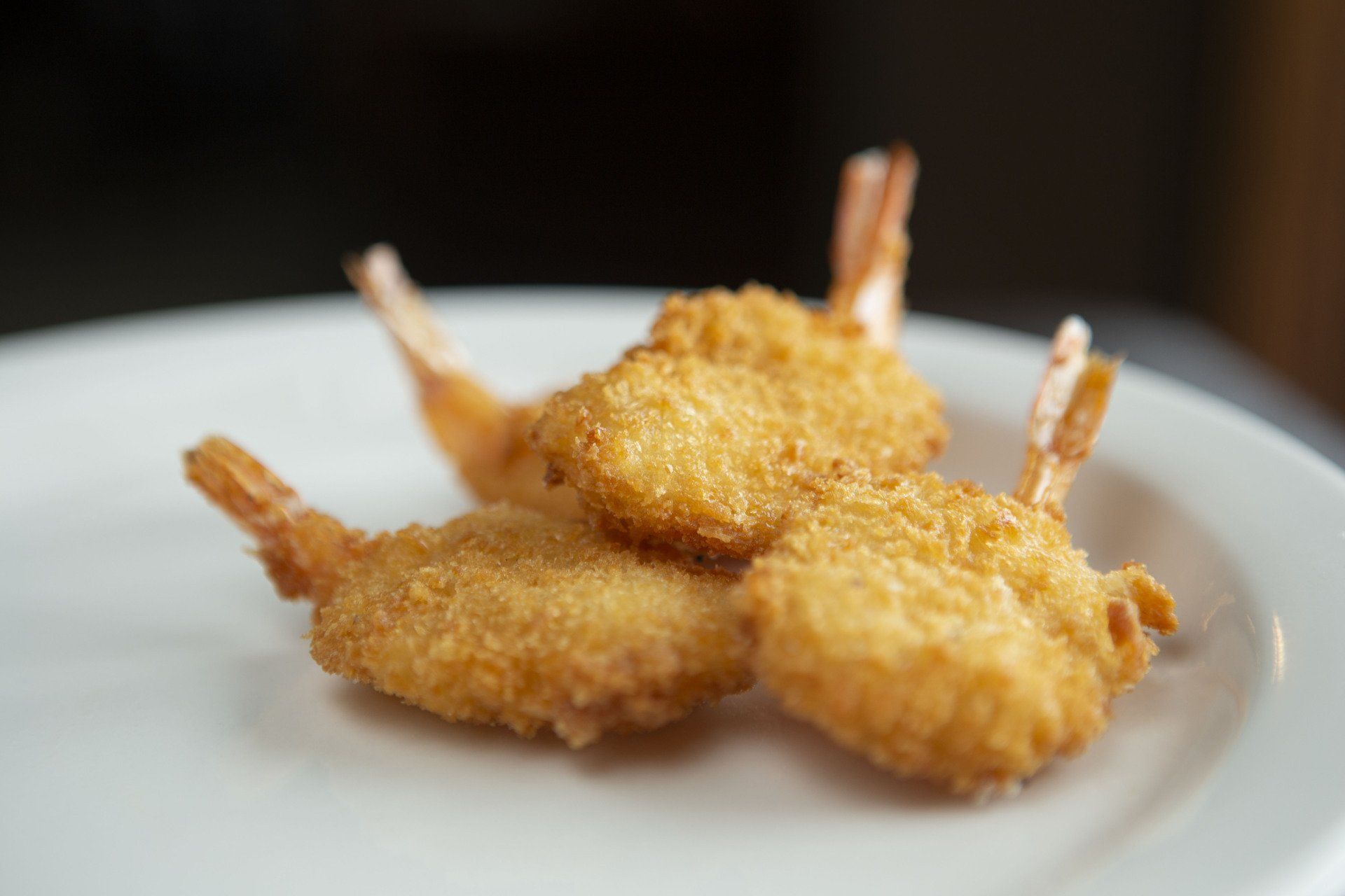 Breaded fried shrimp on a white plate