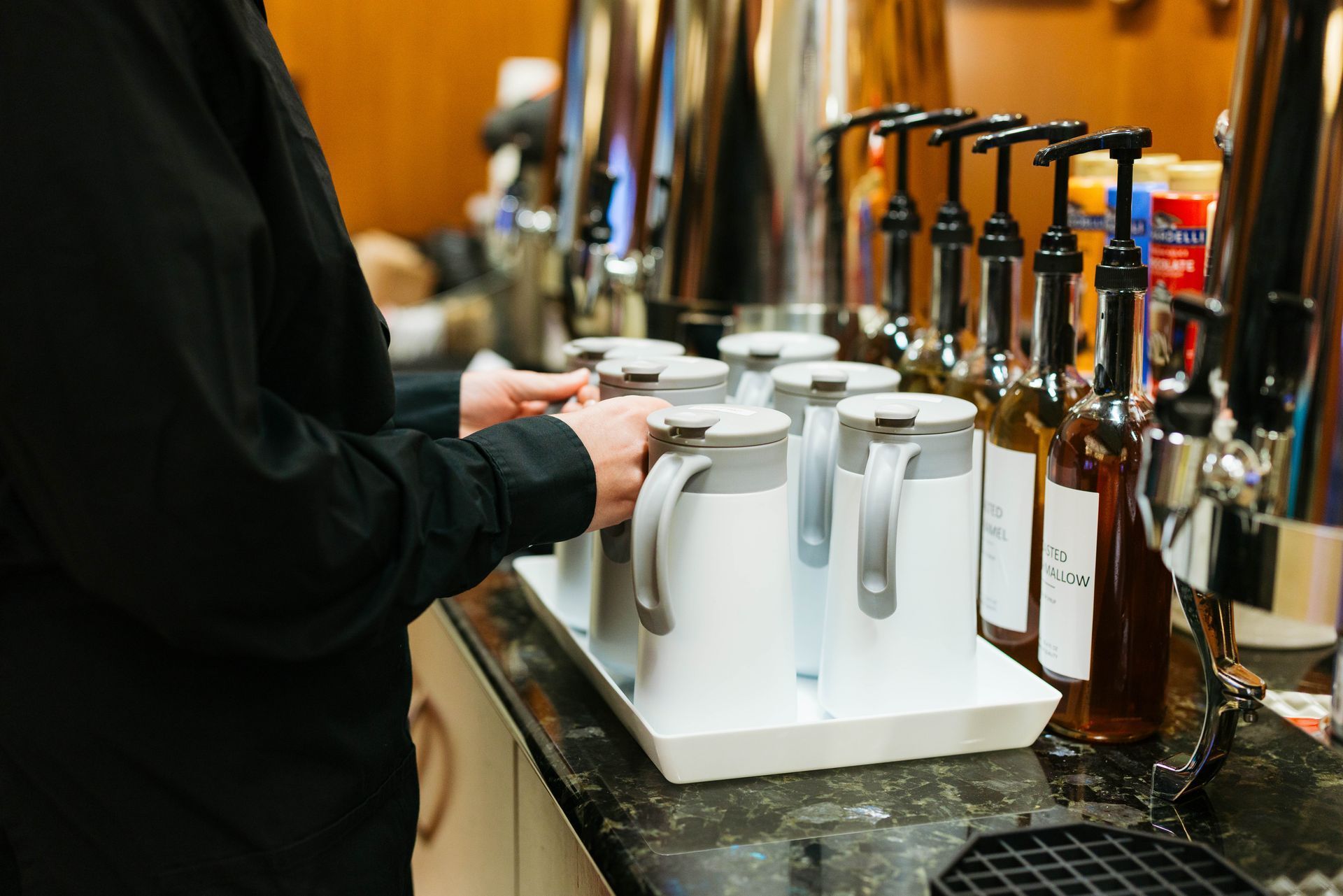 Person filling beer mugs at a bar tap station