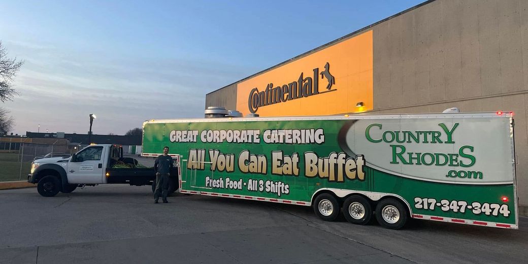 Trailer advertising Country Roads All-You-Can-Eat Buffet outside a Cabela’s store at sunset.