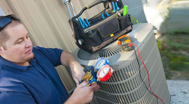 Technician using tools to repair an outdoor air conditioning unit