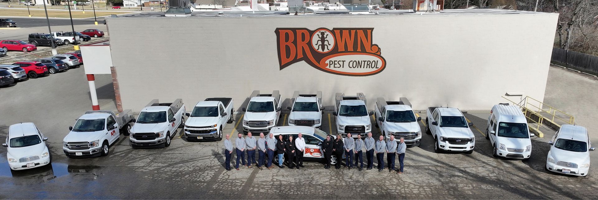 A group of people are posing for a picture in front of a truck.