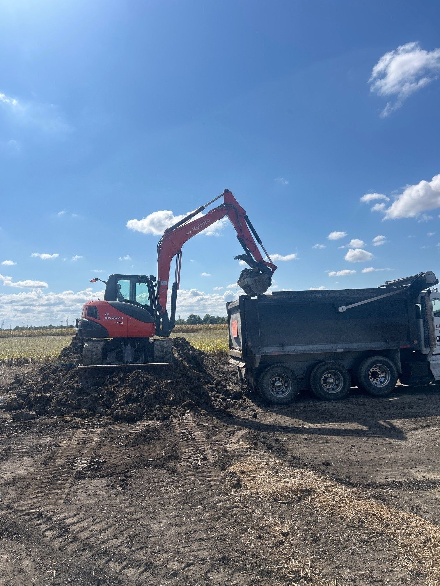 An excavator is loading dirt into a dump truck.