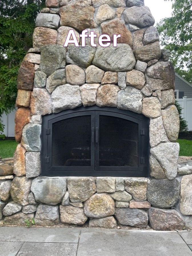 Outdoor stone fireplace with black metal doors.