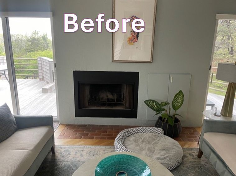 Living room before renovation with fireplace, artwork, and sofa.