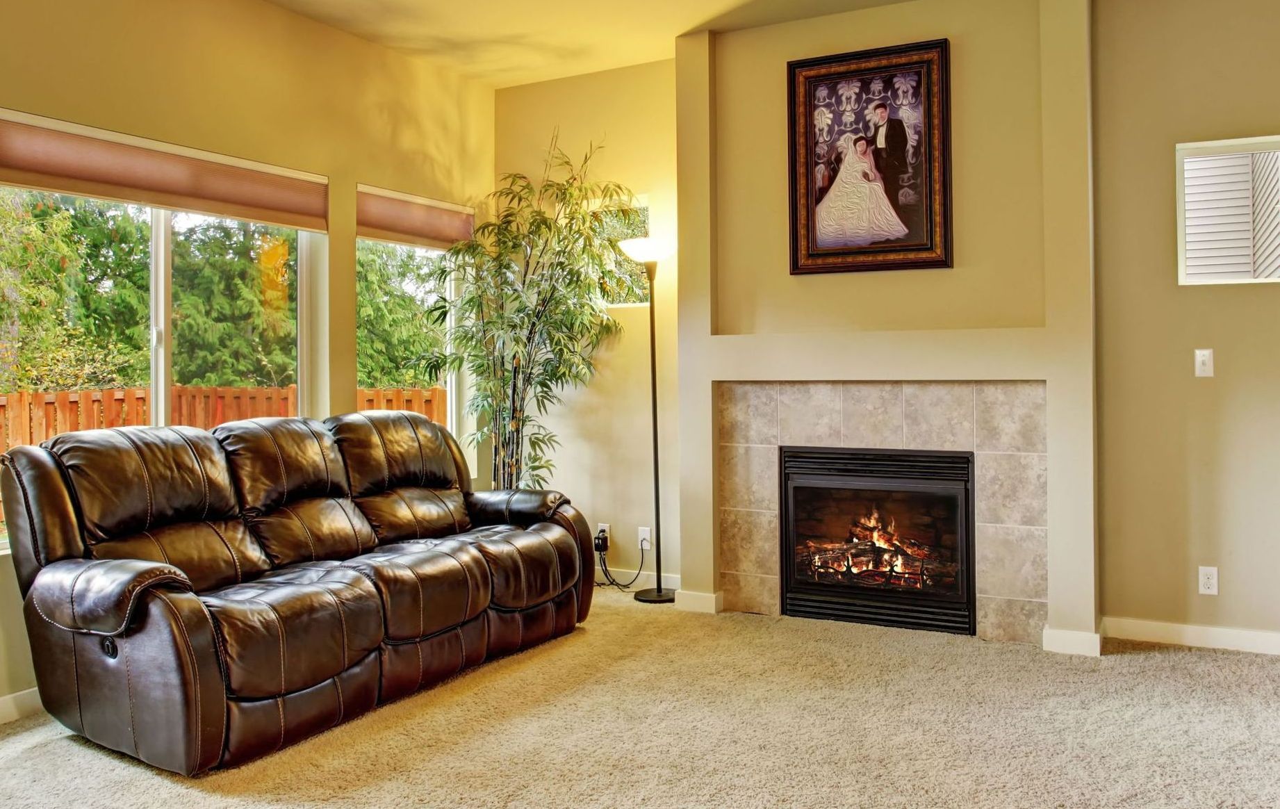 A living room with a couch , fireplace , and picture on the wall.