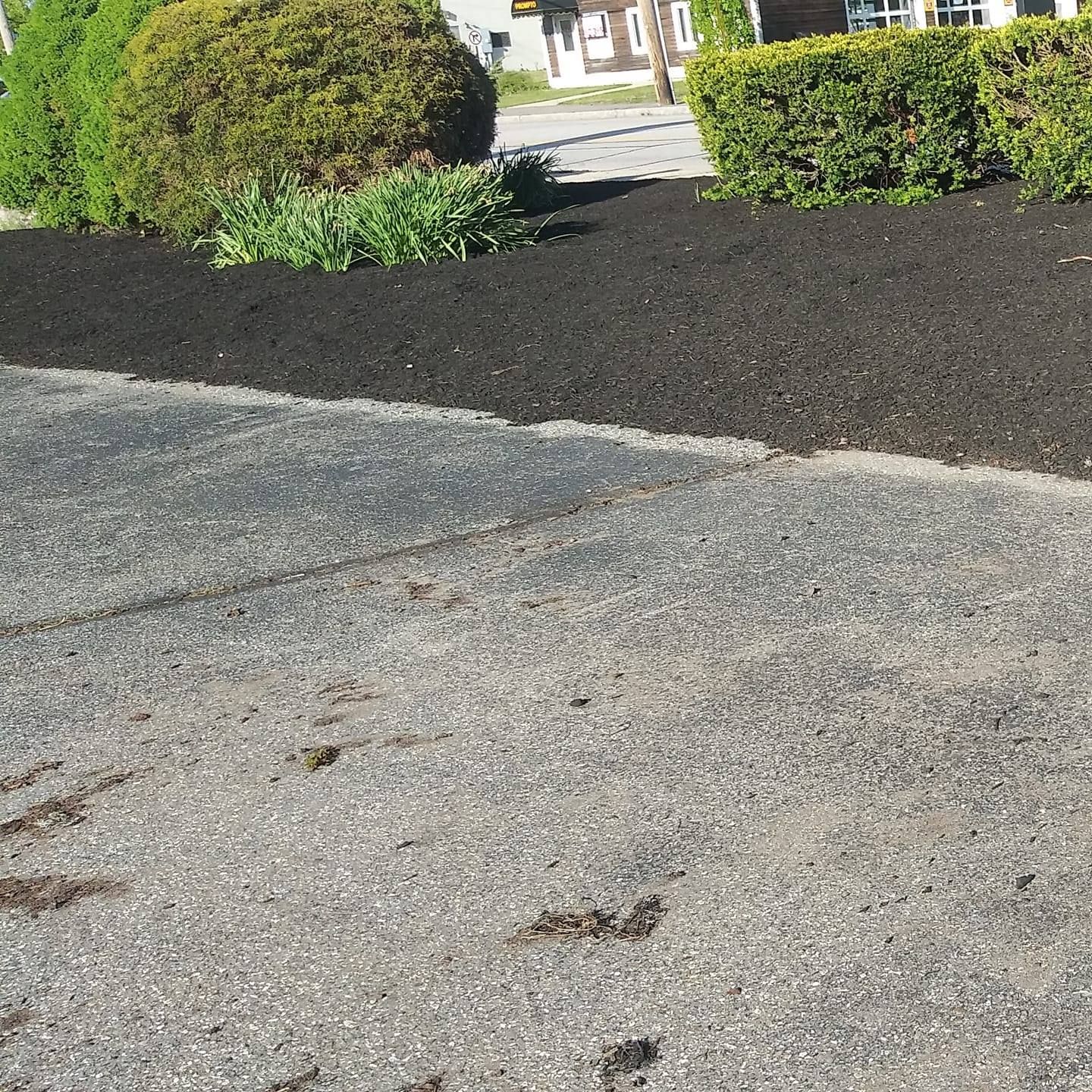 A driveway with a lot of black mulch on it