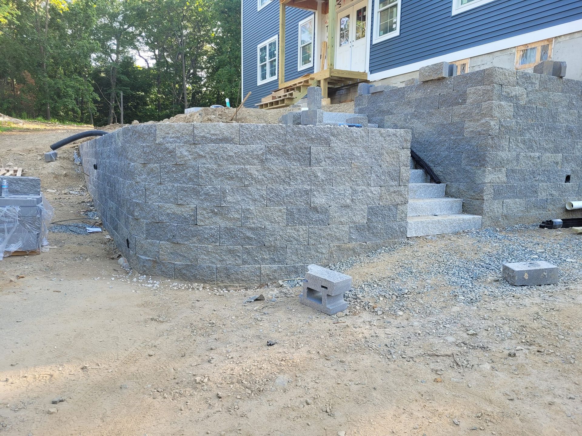 A brick wall is being built in front of a house.