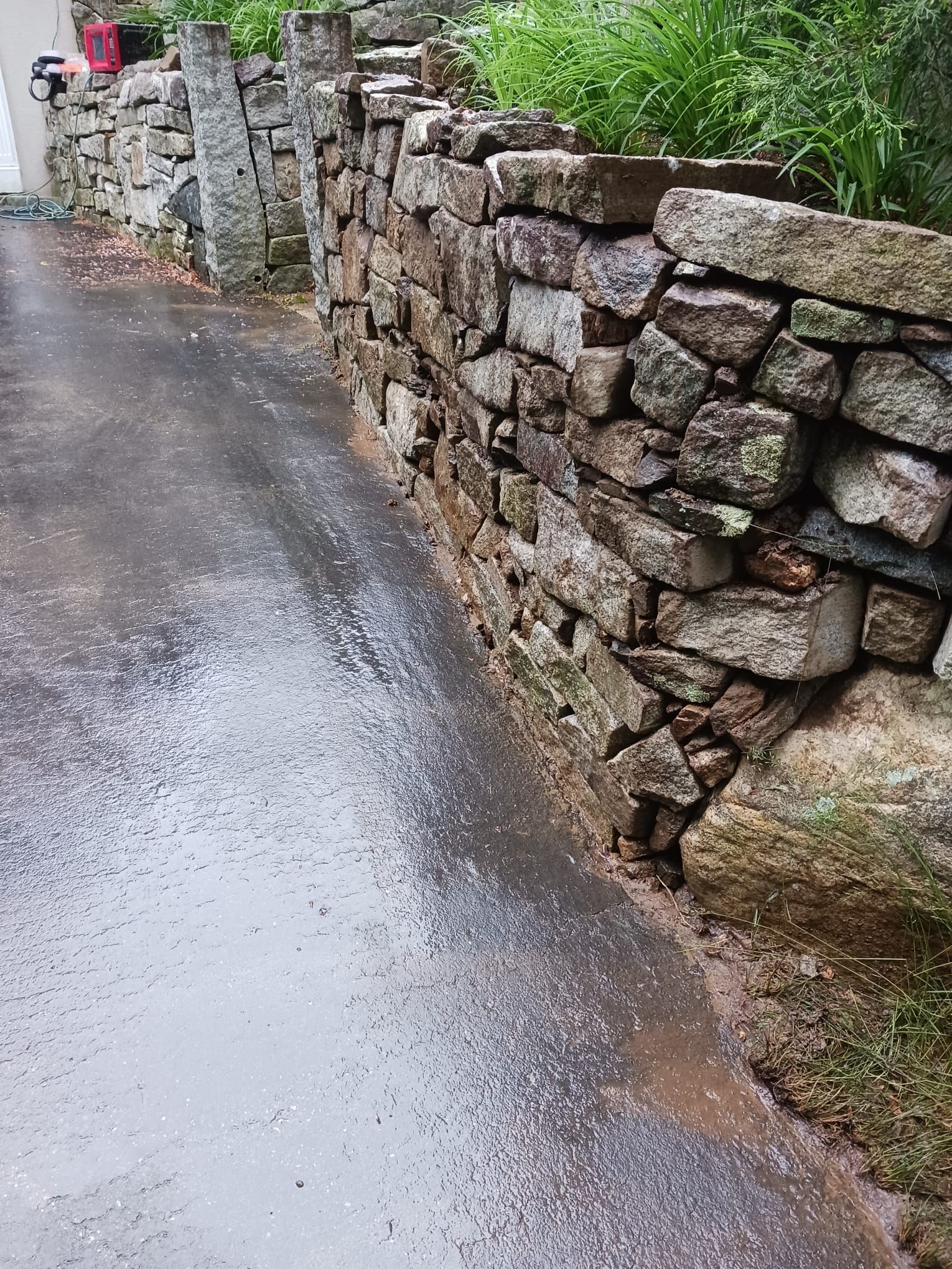 A stone wall along the side of a road.