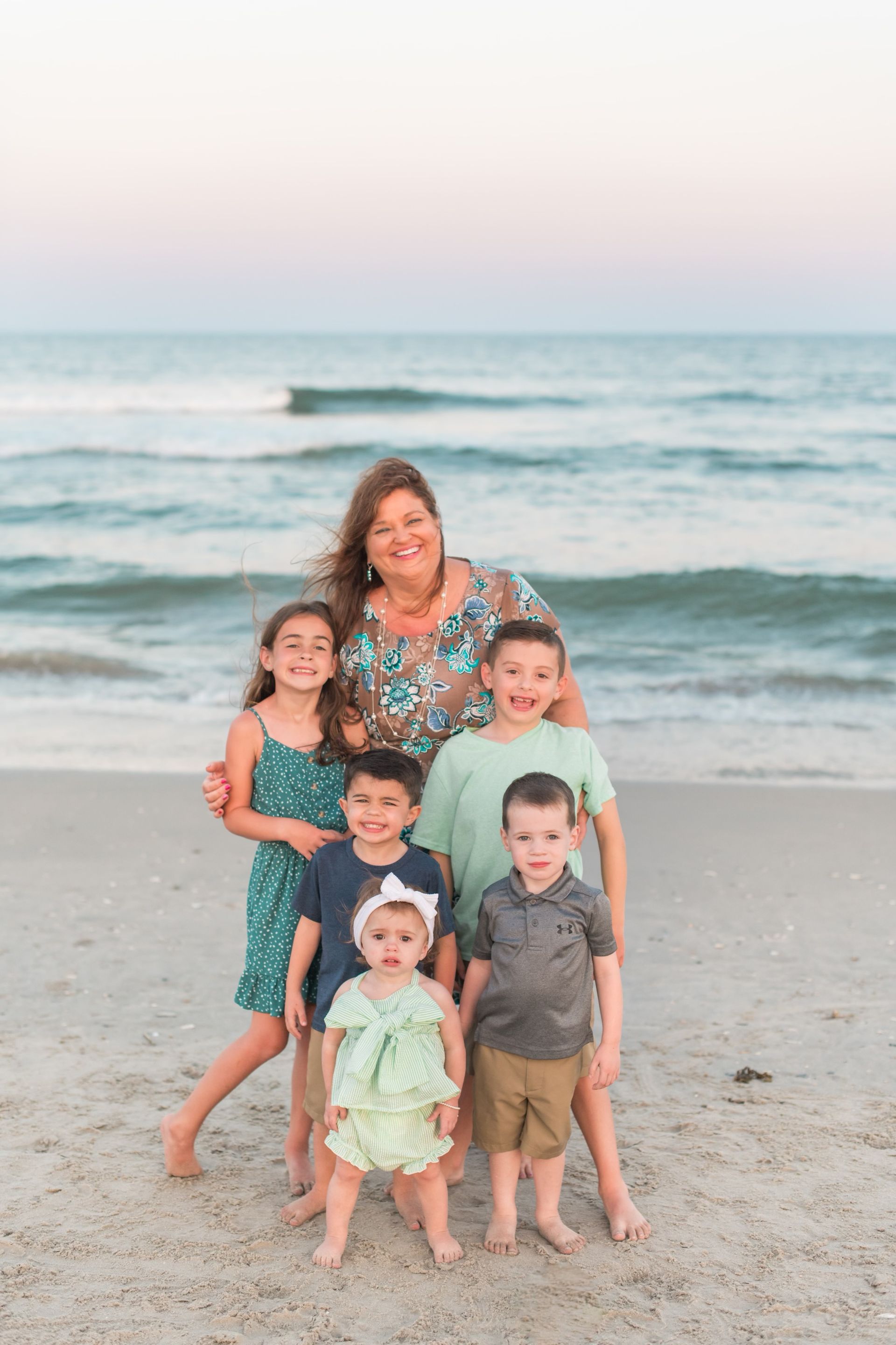 A family is posing for a picture on the beach.