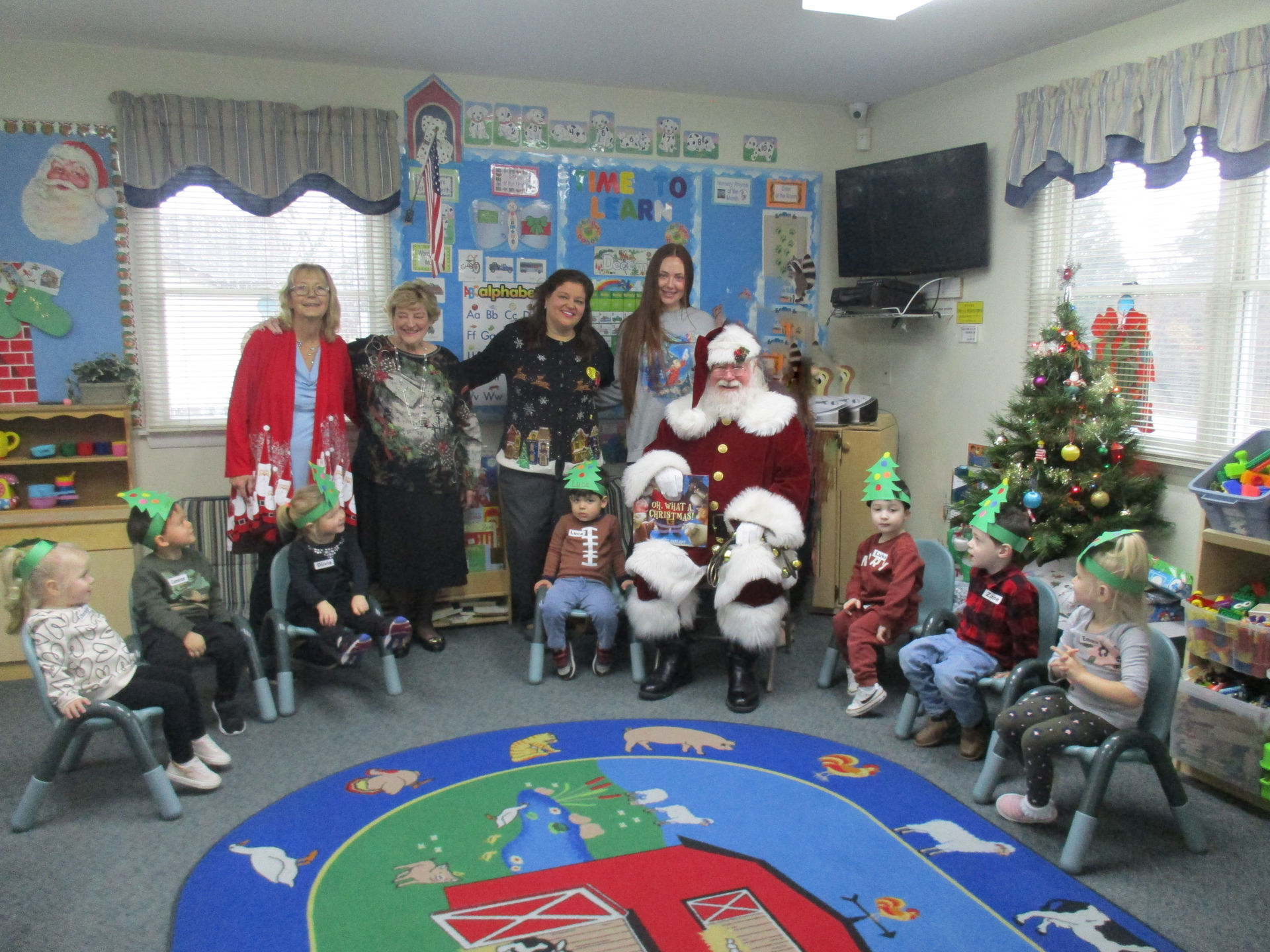 A group of children are posing for a picture with santa claus in a classroom.