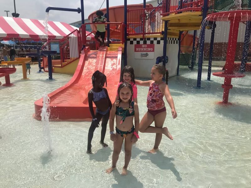 A group of young girls are posing for a picture in a water park.