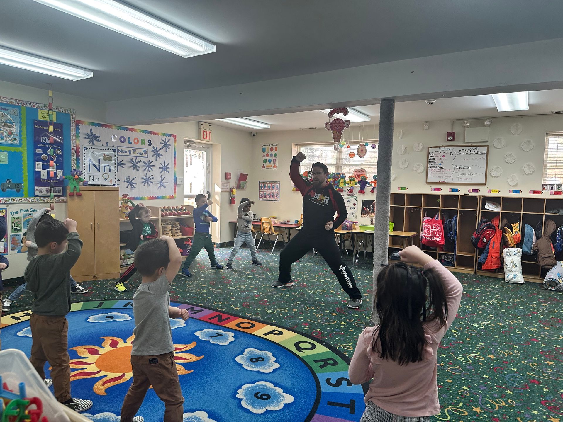 A group of children are playing in a classroom with a teacher.