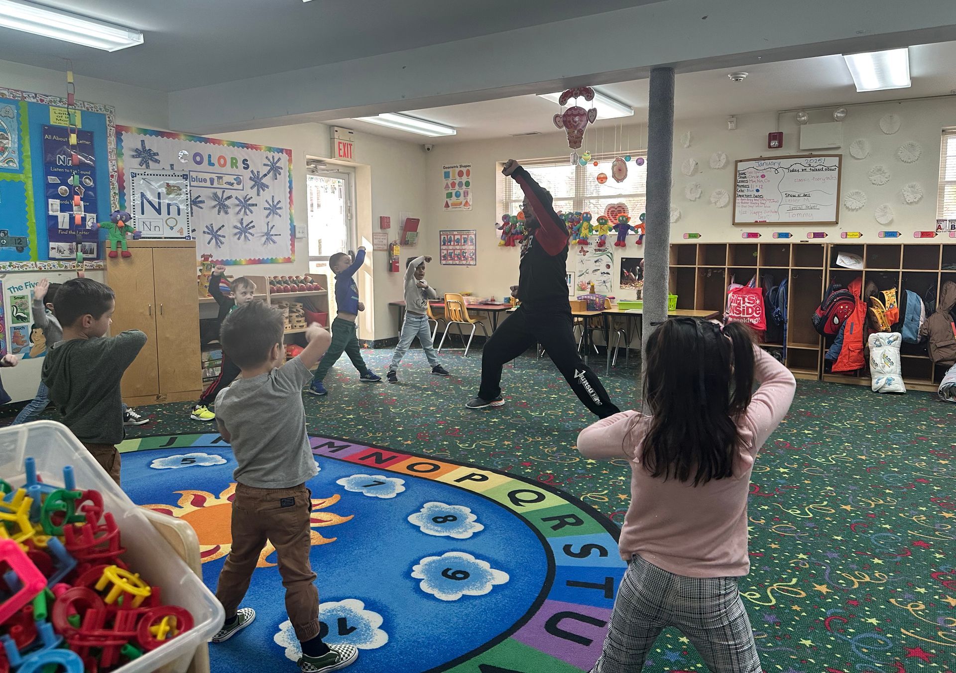 A group of children are doing yoga in a classroom.
