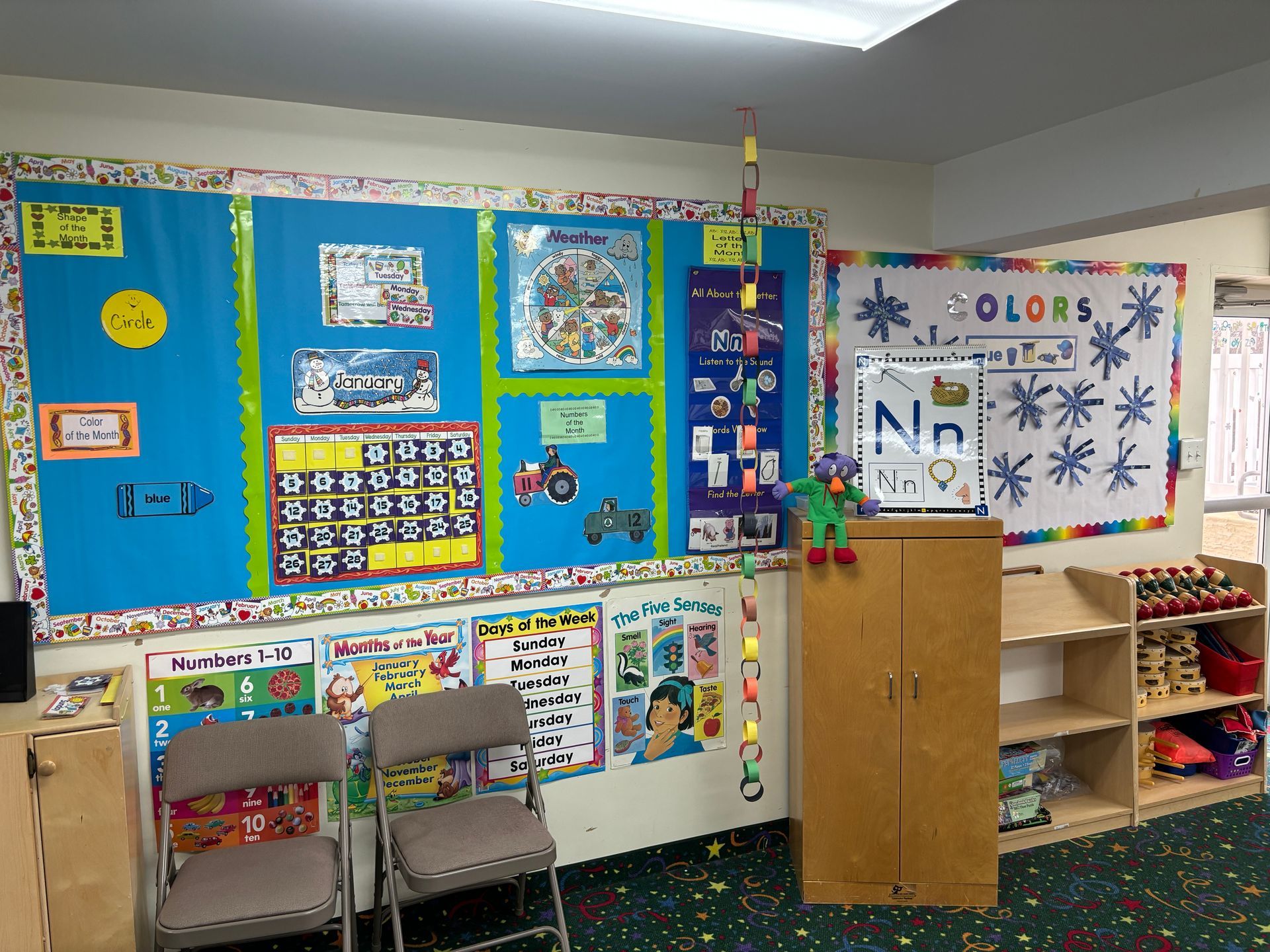 A classroom with a bulletin board that says colors on it