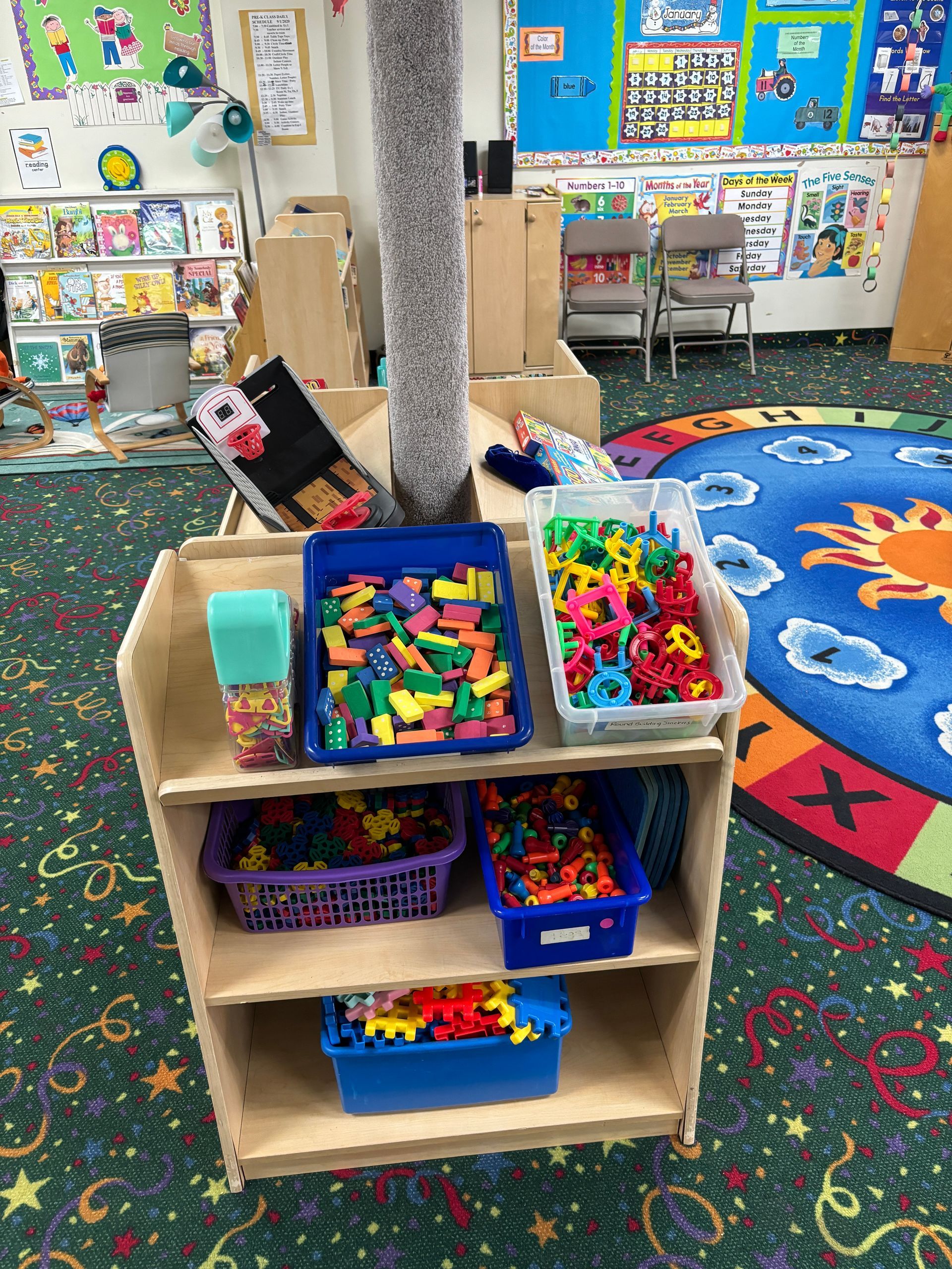 A shelf filled with lots of toys in a classroom