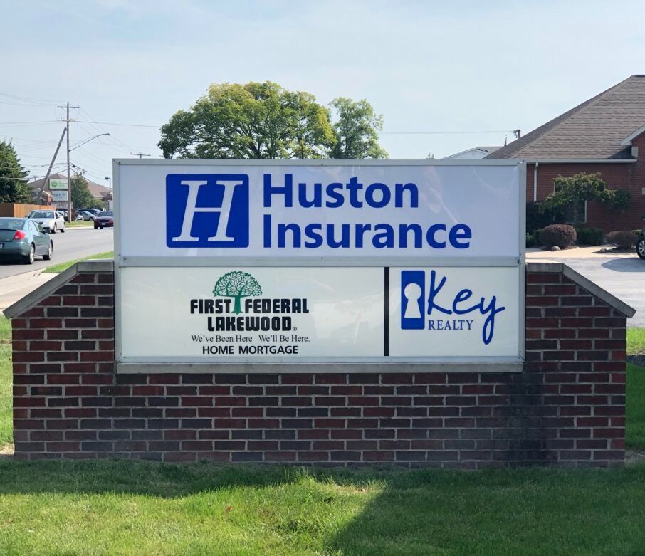 A huston insurance sign with a brick building in the background