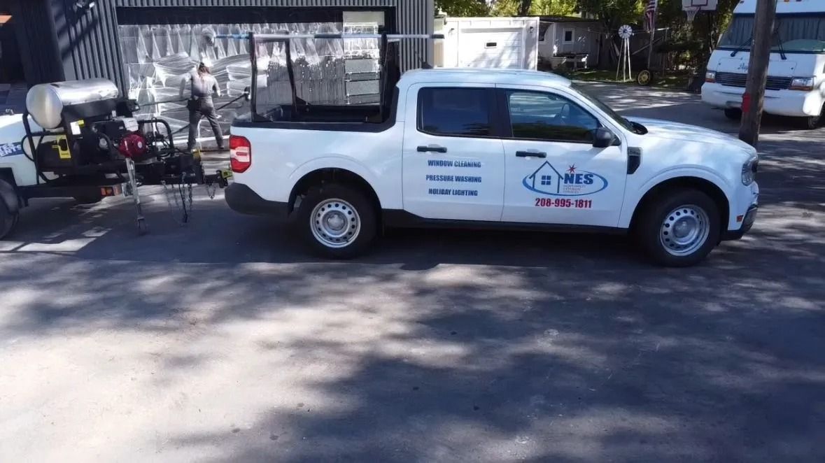 White pickup truck with company logo parked next to trailer with equipment.