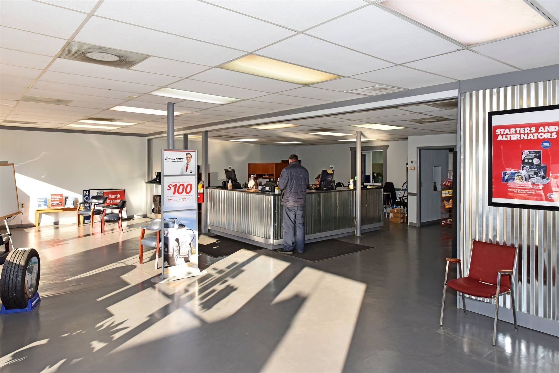 Airport check-in area with people at counters, bright overhead lights, and metal wall panels